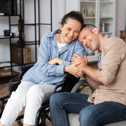 A caregiver sharing a joyful moment with a person in a wheelchair, representing compassionate NDIS support services.