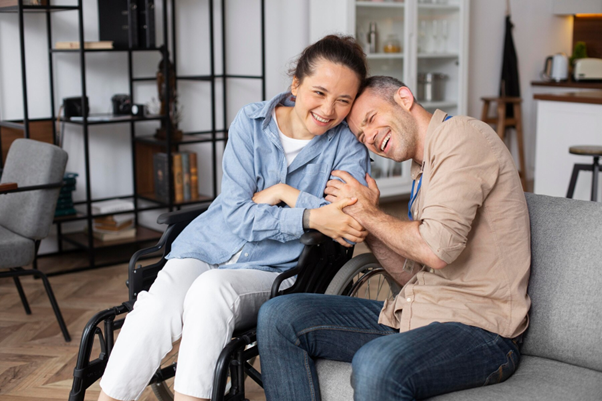 A caregiver sharing a joyful moment with a person in a wheelchair, representing compassionate NDIS support services.