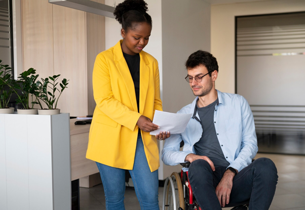 A professional NDIS service provider in Bankstown assisting a person in a wheelchair with documentation and support.