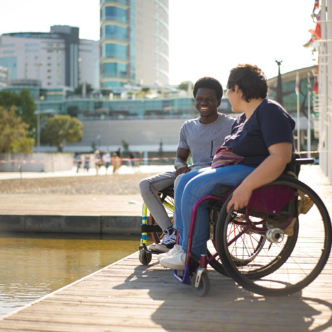 Two individuals in wheelchairs enjoying a conversation by the waterfront in Bankstown, promoting inclusivity and community engagement.