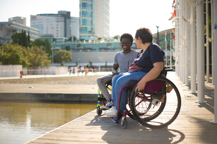 Two individuals in wheelchairs enjoying a conversation by the waterfront in Bankstown, promoting inclusivity and community engagement.